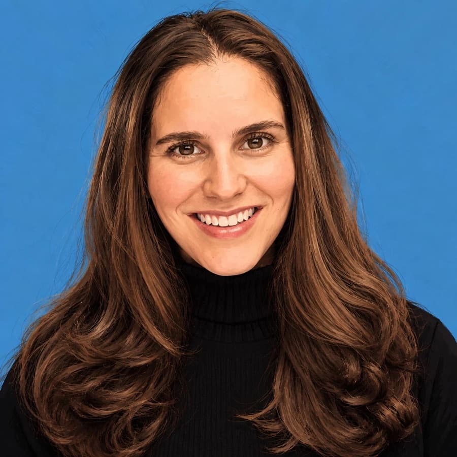 Juliana Gomez-Echeverri, a woman with long brown hair, smiling in a black turtleneck against a blue background